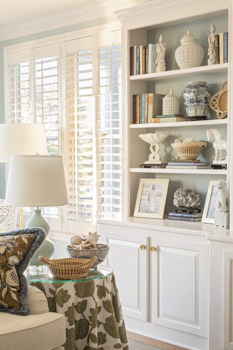 Family mementoes, from treasured photos to an expansive collection of sweetgrass baskets, take pride of place in the built-in shelving, which Horton augmented with aged brass reproduction shutter knobs from the Nathaniel Russel House, sourced at Charleston Hardware Co.
