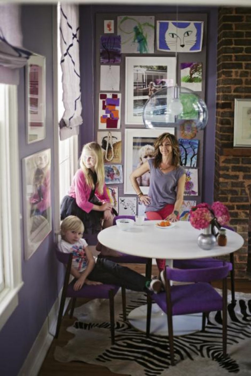 Angie, Loulou (11), and Sasha (seven) in the dining room, which is separated from the galley kitchen by a small partition. The white Tulip table is an eBay find, the chairs are 1960s Danish, and the clear globe pendant is by Kartell.