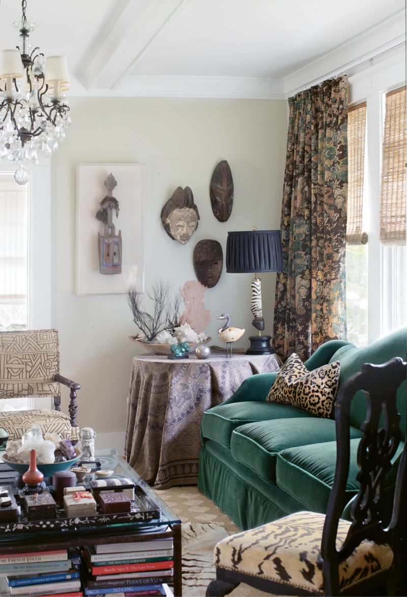 Traditional furnishings, such as 18th-century Swedish rococo chairs upholstered in Scalamandre’s “Le Tigre” silk velvet and a 19th-century Jacobean armchair with antique African Kuba cloth, mingle with African masks and floral-style arrangements of sea coral.
