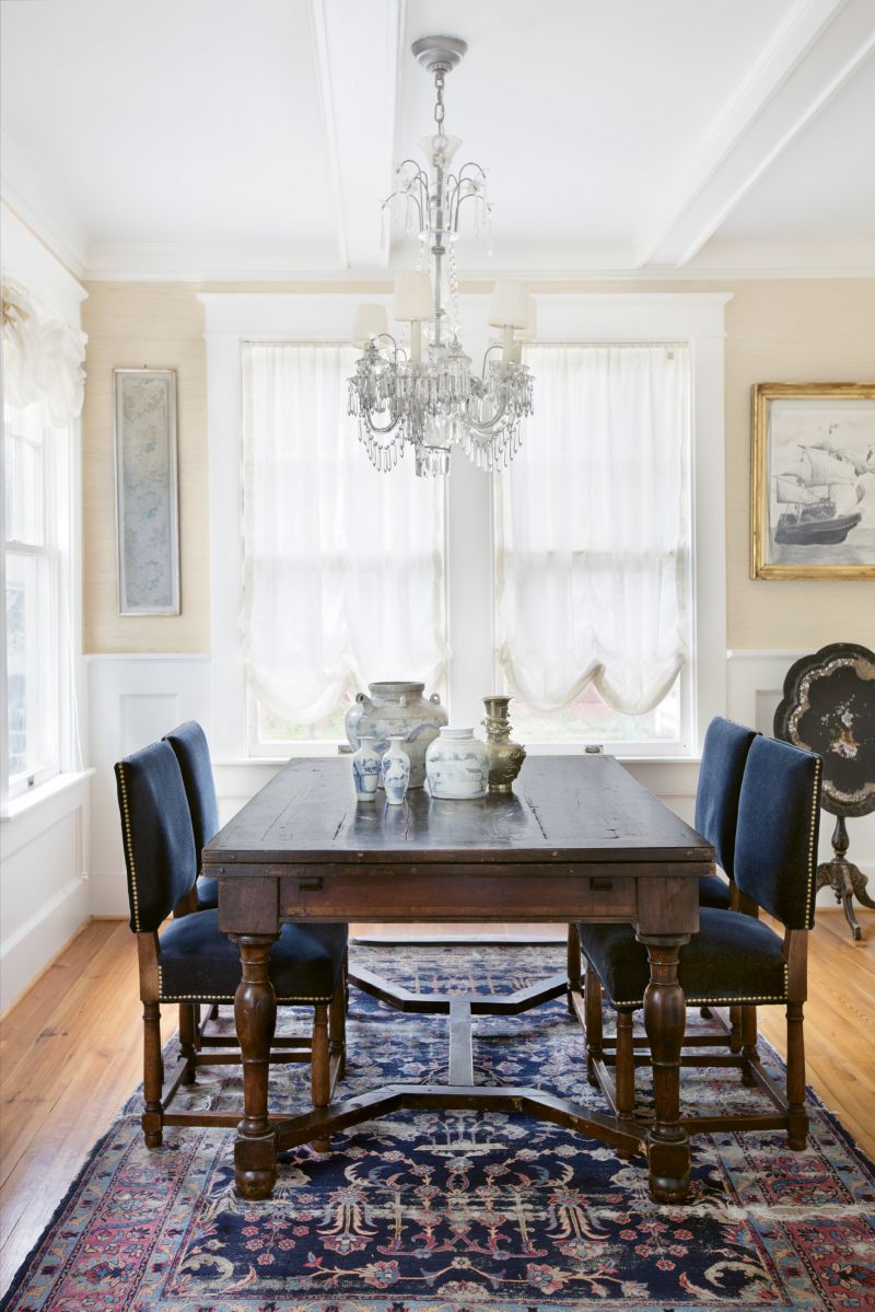 In the Navy: Deep blues and neutrals set the tone in the dining room, where the chairs are upholstered in blue mohair. The artwork includes a framed Chinese embroidery remnant as well as a pencil drawing of a naval ship that Melvin completed in high school. Debbie found it during one of their moves and had it framed in honor of his years of Navy service.