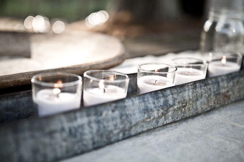 LIGHT THE WAY: Ashley says, “I’m a sucker for some soft, romantic lighting.” She sprinkled simple votive candles throughout the décor—here, lining them within a rustic metal vessel.