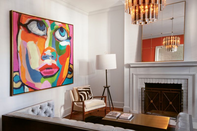 Balancing Act: In Dr. Eddie Irions’s living room, a few bold statement pieces—such as a colorful portrait by Brazilian artist Robson Reis Marques and an Art Deco chandelier—are grounded by a mostly neutral palette.