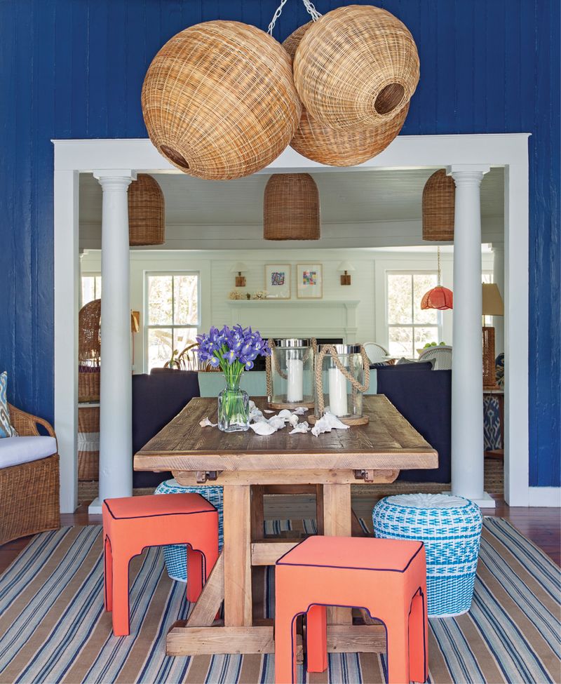 Woven Whimsy: A custom-designed cluster of wicker pendant lights from Serena &amp; Lily dominates the entryway/dining room. A vintage cabinet from Indigo Market provides storage space as well as a showcase for two striking lamps from Chairish and a mirror from Candelabra.