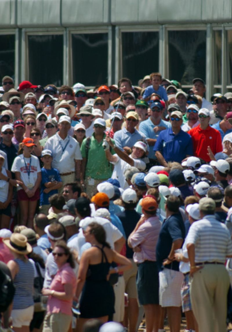 Bubba Watson hitting out of a crowd to the 18th green.