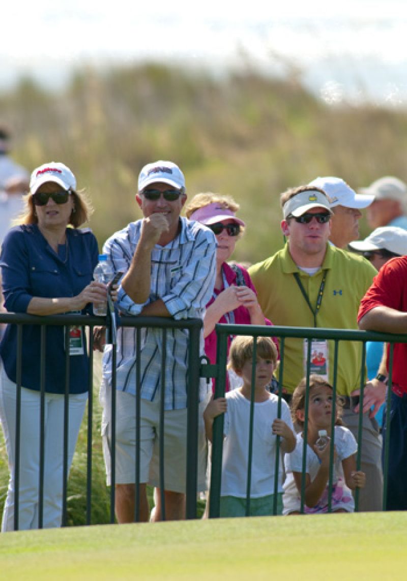 Fans watching Phil Mickelson on the putting green.