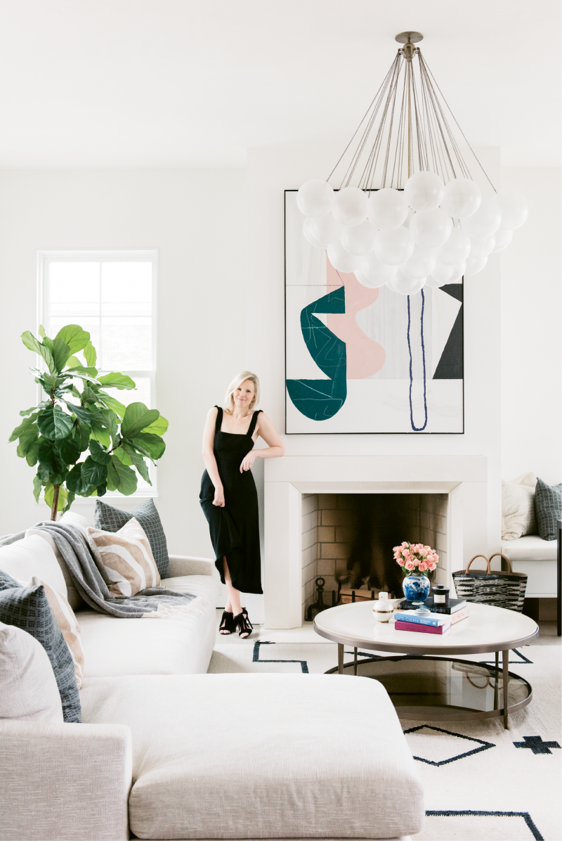 Molly Fienning in the living room near an abstract painting by Brian Coleman; “I fell in love with his work at the George Gallery downtown, so we commissioned him to create sister paintings that complement one another,” she says.