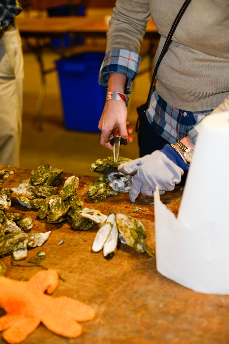 Hungry partygoers crack open their oysters.