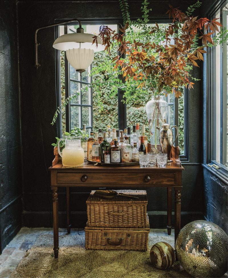 Tucked inside the entryway, a well-stocked bar and the evening’s batched honey-basil margarita sit atop an antique sideboard.