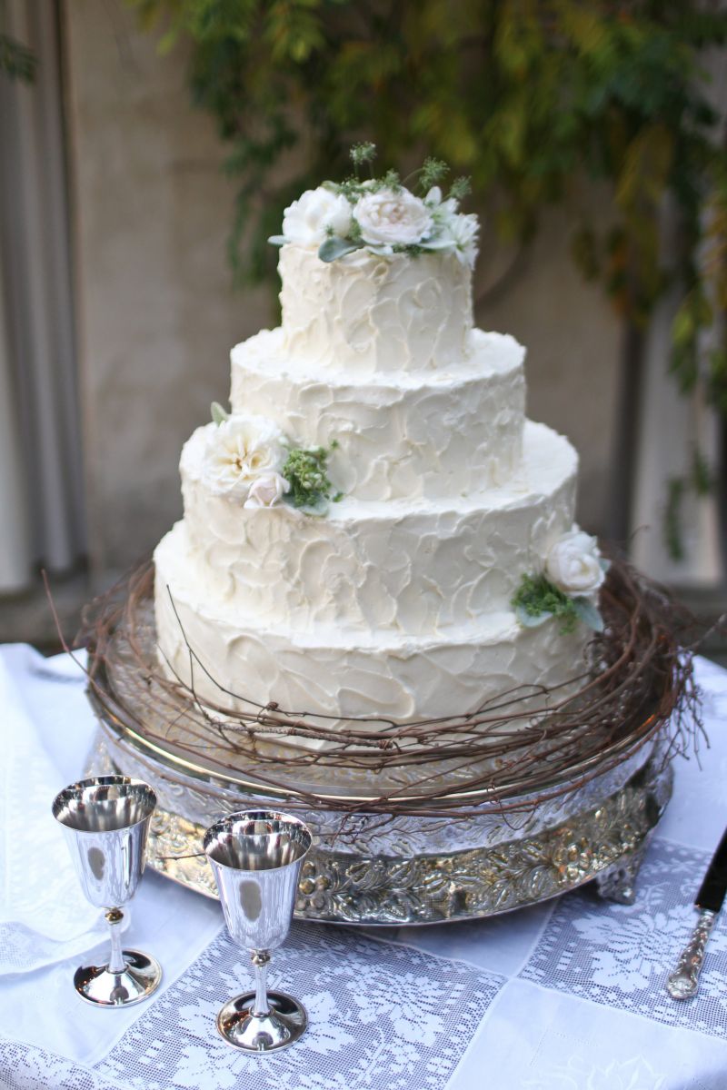 A TIER-FUL SIGHT: Real flowers and a skirt of thin sticks tied the cake into the rest of the reception décor.