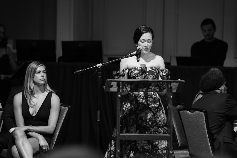 Laura Reed delivers a speech alongside emcee Katy Solt (far left).