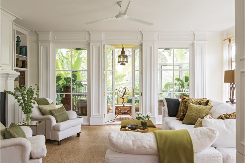 Alexandra took inspiration from the lush tropical garden when honing the family room’s crisp green-and-white color palette.  (Opposite) Shaded by banana trees, the screened porch is designed to feel like an adult tree house.