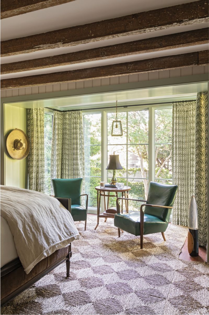 MORE THAN THINGS: A checkered seagrass rug and custom drapes in a verdant design embrace this guest suite, which overlooks the garden. “These chairs came from an Italian antiques fair,” says Michael. “And I bought that lamp when I was at a woodworker’s shop in Arkansas—I thought it was sweet.”