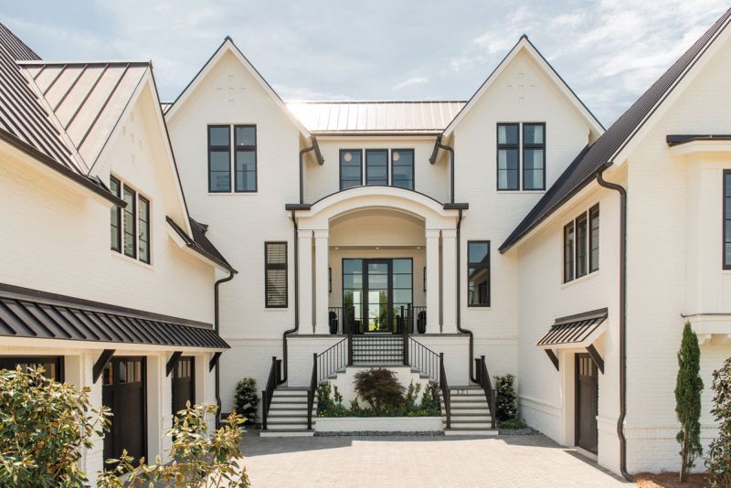strong foundation: With its pitched roofline, painted-brick exterior, and arched entry, the 6,000-square-foot residence nods to French countryside architecture. Architect Damien Busillo and builder Roy Mahshie worked together to ensure this marsh-front property is as strong as it is stunning.