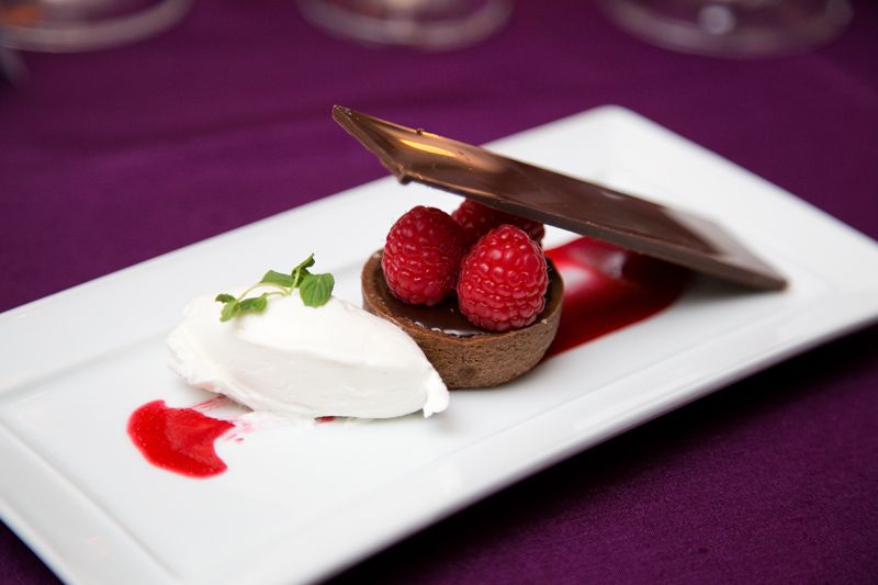 The meal ended with a dessert featuring a chocolate salted caramel tart and fresh raspberries.