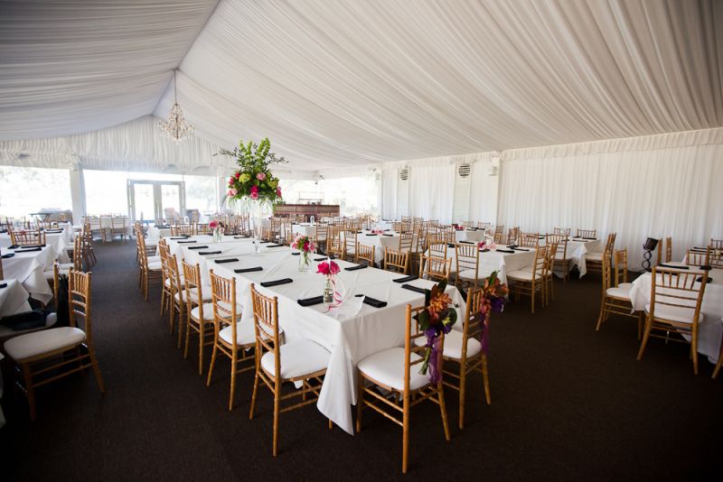 A TENTED AFFAIR: The high-topped tent, provided by the Cassique Clubhouse, allowed for a spacious reception. The draped white fabric and one clear wall balanced out the hall’s dark floor.