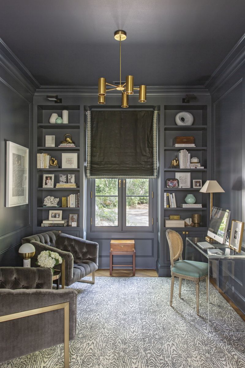 MOODY HUES: Stevenson’s home office separates the living area from the primary suite on the main floor. Painted in Benjamin Moore’s dramatic “Witching Hour,” it provides a transition between the two spaces. The Schoolhouse “Plaza” brass chandelier adds drama, while the Stark wool rug softens the scene.