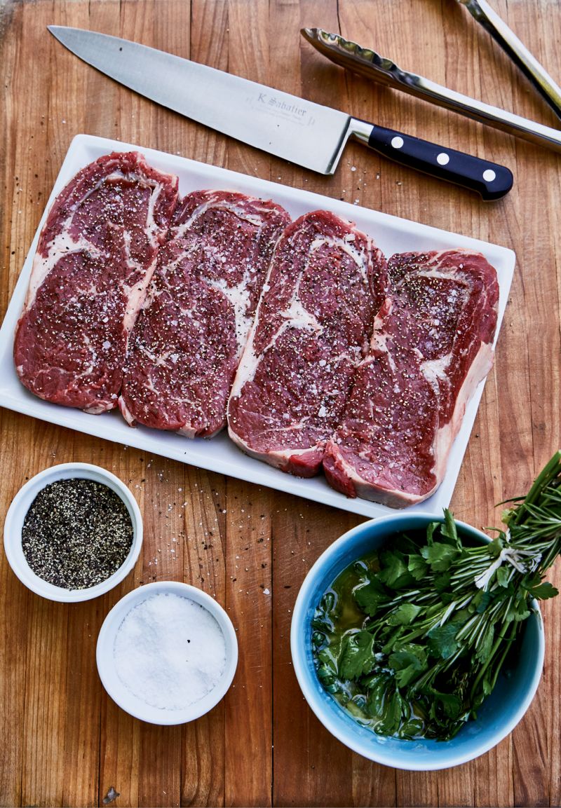 To glaze the rib eyes, DiBernardo bundles together savory herbs (thyme, rosemary, parsley, and tarragon), dunks them into melted garlic butter, and then brushes the meat. Don’t overcook your steaks; they only need about seven to 10 minutes on the grill for rare.