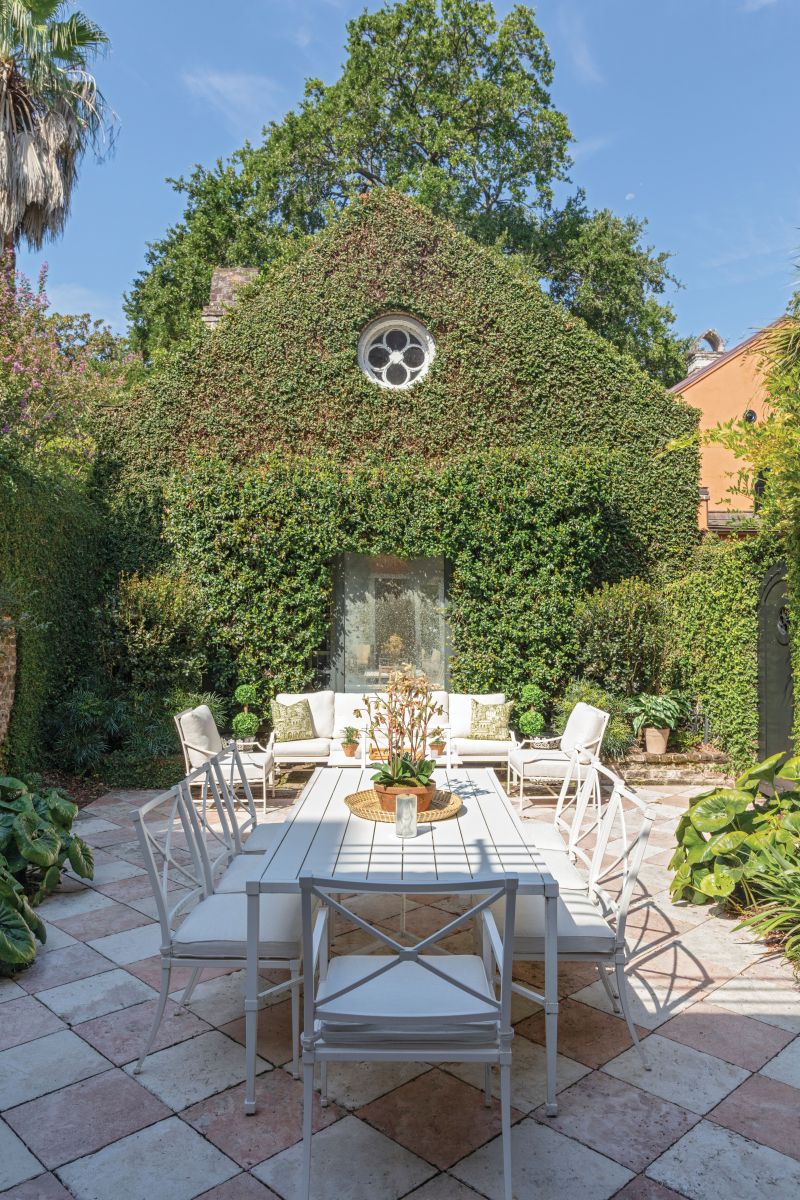 Holding Court: A white Restoration Hardware dining table and seating in the courtyard garden allow the natural beauty of the space to shine. The rear structure was originally a dependency of the main home but was sold by the previous owner.
