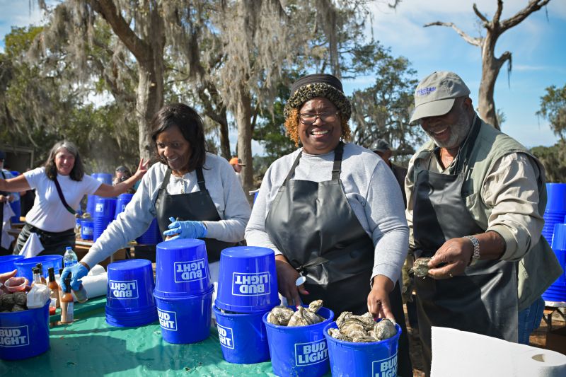 Volunteers from the Hollings Cancer Center distribute oysters for hungry guests during the Lowcountry Oyster Festival.