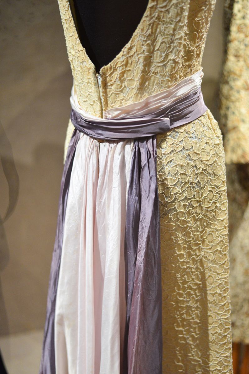 A detailed cocktail dress with a purple sash