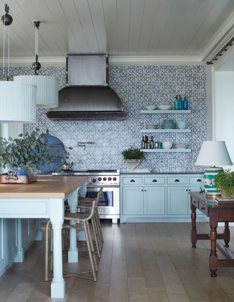 Tile Style: The kitchen cabinets and island, painted in a calming “Au Contraire” by C2 Paints, set off the white oak floors and butcher block countertop, providing a soft palette to showcase the stunning wall of terra-cotta tile from Waterworks. The blue “bangles” pattern of the Redbank decorative field tiles is topped by a handmade pewter hood, which complements the Grey Imperial marble countertops.