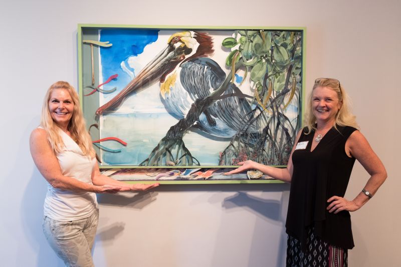 Kaycie Lane and Pam Wimholtz pose in front of the artwork.