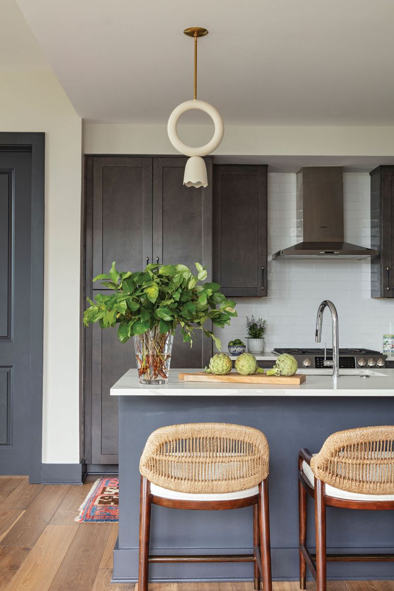 In the kitchen, handcrafted ceramic light fixtures by Rory Pots in Vermont pair with wicker stools from Palecek for an organic touch