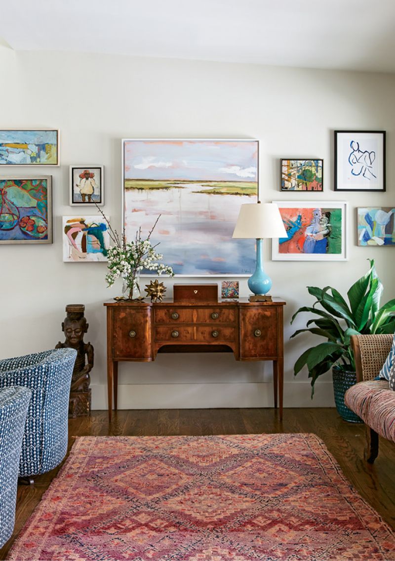 Changing Scenery: This gallery wall in the living room is always in flux. “I constantly change it out,” Allison says. Works by Charleston Artist Collective members dominate this iteration, including pieces by Shannon Wood (center) and Lynne Hamontree (top right).