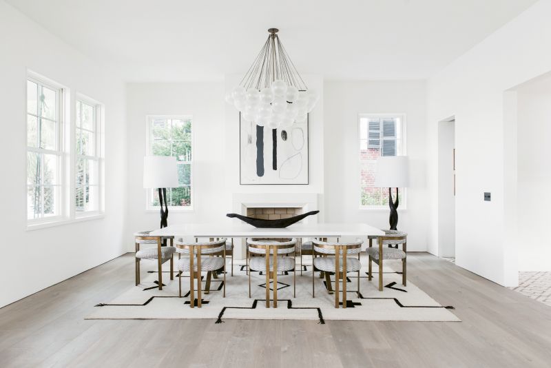 In the dining room, sculptural elements such as the Apparatus “Cloud” light fixture, Kelly Wearstler dining chairs, and a custom Merida rug woven with leather straps are like functional works of art.