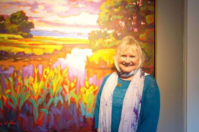 Artist and gallery owner Betty Anglin Smith posed in front of a Lowcountry scene.
