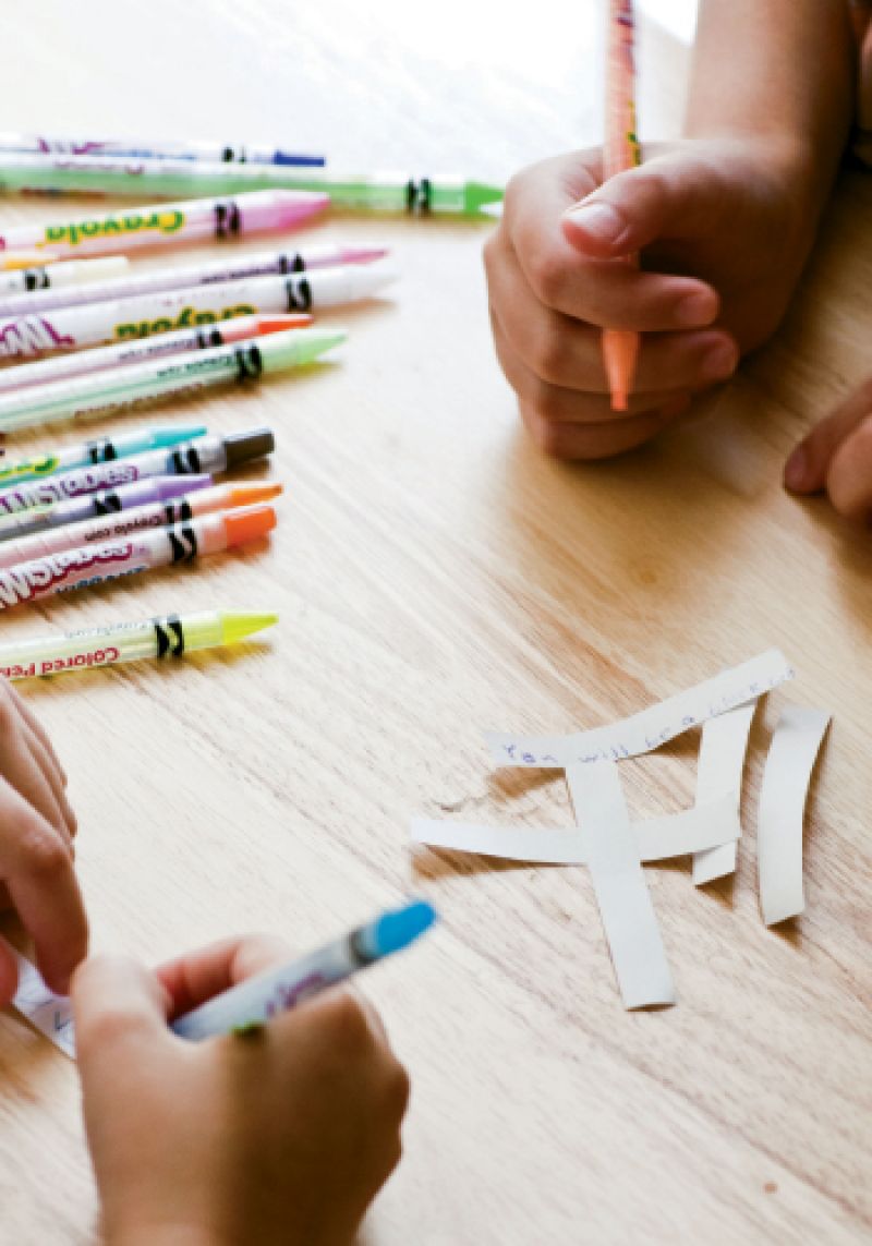 Using bright markers, Matthew and Christian pen fortunes to put inside the cookies; favorites include “You will be a black belt” and “In food there is love” (from Mom).