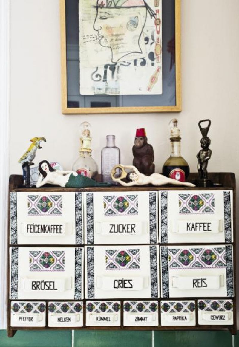 Whimsical bottle openers top a European spice rack with ceramic drawers, while a collage by California artist Inez Storer hangs overhead.