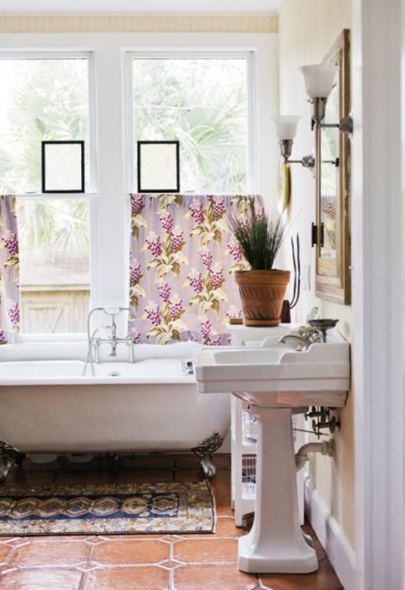 bath house: A clawfoot tub with cast-silver detail sits beneath the windows in the sunny rear bathroom addition.
