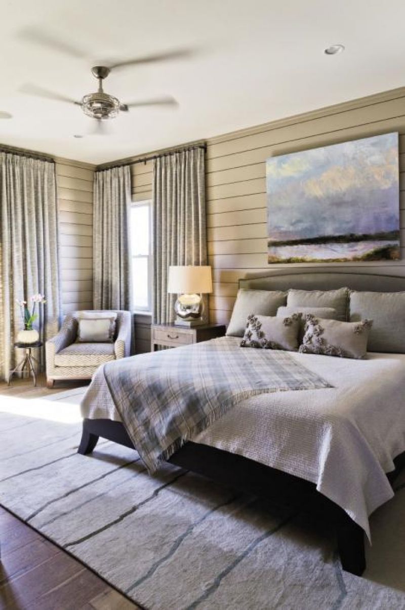 Mellow Out: Poplar wood paneling wraps a master bedroom (one of two in the house). The Tufenkian rug is from Tibet and the landscape painting is from Rebekah Jacob Gallery.