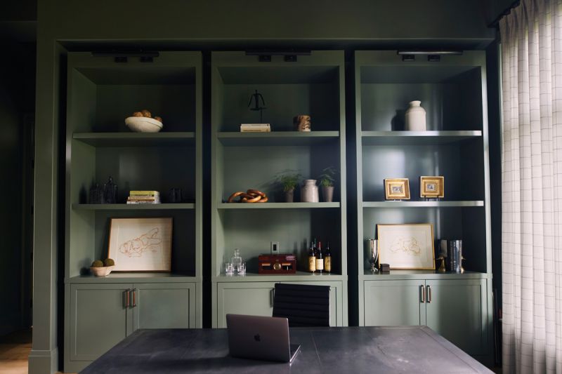 David’s office offers a change of pace. A dark wood Restoration Hardware desk, leather sofa from Four Hands, and shelves painted Benjamin Moore “Rosepine” create a calm space, perfect for contemplating the views over the marsh.