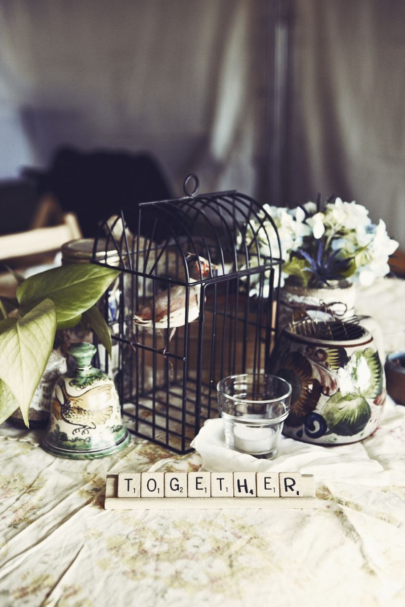 STILL LIFE: Fabric found in a thrift store—and sewn into tablecloths by Lisa&#039;s mother—served as the foundation for the wedding&#039;s aesthetic while vintage pottery, miniature wrought iron cages, and vases filled with flowers provided the collected look Lisa and Seth love.