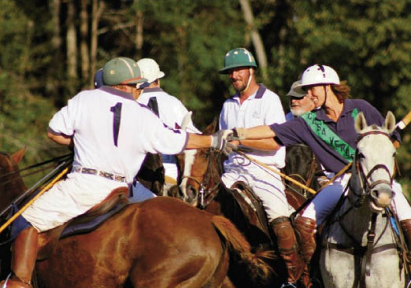 After the shouldering ferocity of the chukkers and the windup for a final shot, all eight players meet on the field to shake hands at the end of the match. Three players leaning in for this bit of polo etiquette are Barry Limehouse, Todd Martineau, and Elisa Cashin.