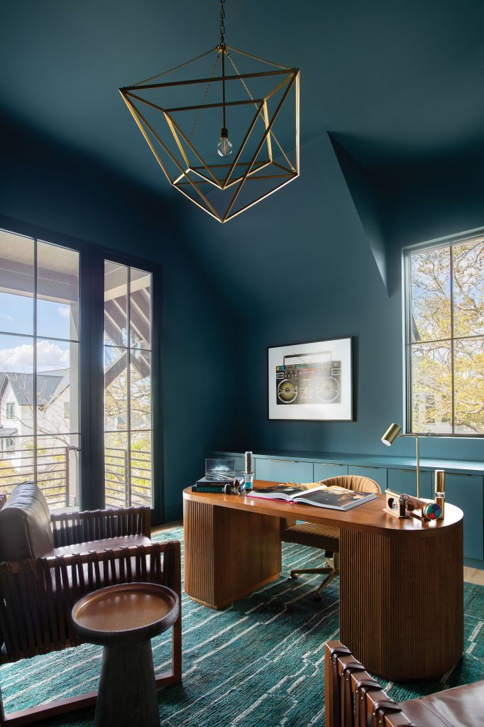 <strong>Rich Hues</strong> - Designer Hollis Erickson swathed the walls, ceiling,  and consoles in a deep blue-green (C2 “Titan”), allowing the mid-century modern desk from CB2, leather “Commodore” chairs from Palecek, and chandelier from Visual Comfort to stand out. A green Moroccan rug from Moattar in Atlanta ties it all together. <strong>Location:</strong> Daniel Island <strong>Issue:</strong> March 2023, “Thinking Outside the (Black) Box” <strong>Photographer:</strong> Margaret Wright  <a href="https://charlestonmag.com/features/nestled_among_the_trees_on_a_marshfront_daniel_island_lot_the_contemporary_black_house_is_a"><strong>&gt;&gt;CLICK HERE TO READ THE ARTICLE</strong></a>