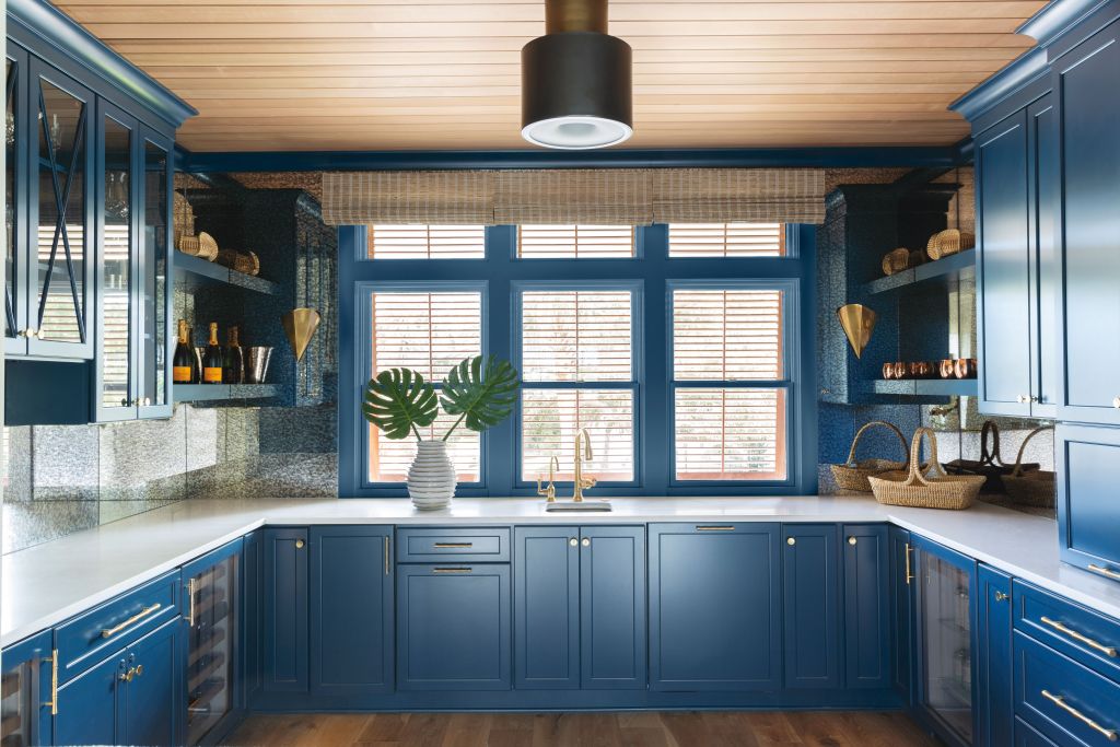 <strong>Blue Heaven</strong> - Adjacent to a minimalist kitchen, this striking room—with cabinets painted in “Rainstorm” by Sherwin Williams and an antiqued mirror backsplash—tucks away appliances and entertaining ephemera. <strong>Location:</strong> Mount Pleasant <strong>Issue:</strong> November 2019, “Shem Creek Chic” <strong>Photographer:</strong> Julia Lynn  <a href="https://charlestonmag.com/features/shem_creek_chic_how_one_couple_transformed_an_ornate_90s_house_into_a_modern_waterfront"><strong>&gt;&gt;CLICK HERE TO READ THE ARTICLE</strong></a>