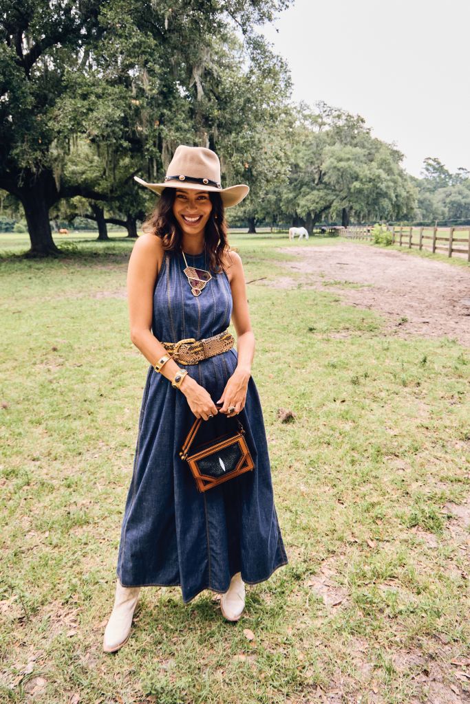 <b>Green Pastures:</b> Brunello Cucinelli denim dress, $2,295 at Gwynn’s of Mount Pleasant; Marsh &amp; Magnolia “Standard” hat, $175 at Marsh &amp; Magnolia; W. Kleinberg python belt, $440 at RTW; Freebird “Woodland” boots, $275; Dean Davidson “Nomad” square hoop earrings, $250 at Well Furnished; Brackish “Amarna” statement necklace, $305 at Rhodes Boutique; bangles, $50 each at 7 Hills Living; Gold Creations oval tigereye scalloped ring, $1,495, and estate smoky topaz branch-style ring, $2,150, both at Gold Creations; Boysterous messenger clutch in stingray leather, $1,400 at Boysterous.