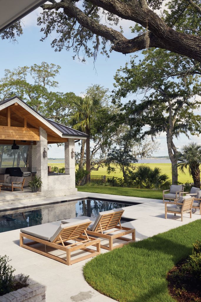 <strong>Riverside Revelry</strong> - In this backyard on the Ashley, a spacious kitchen and living room overlook the pool area with furniture from Teak + Table. <strong>Location:</strong> West Ashley <strong>Issue: </strong>June 2023, “Room to Grow” <strong>Photographer:</strong> Blake Shorter <a href="https://charlestonmag.com/features/after_snapping_up_a_choice_lot_on_the_ashley_river_a_couple_built_a_family_home_that"><strong>&gt;&gt;CLICK HERE TO READ THE ARTICLE</strong></a>