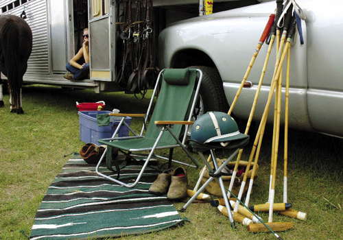 Bridles are hung on the trailer, and each player sets up a spot to kick off his shoes and pull on his boots.