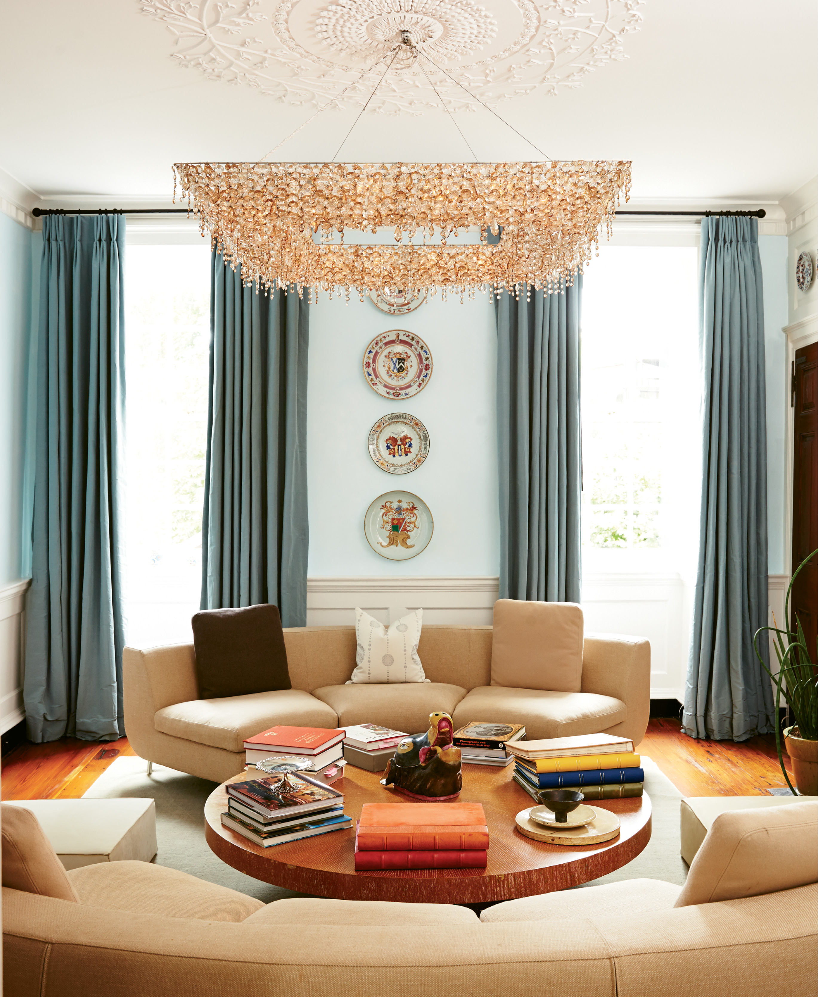 HIGH, LOW, &amp; IN BETWEEN: The Pollaks enlisted jewelry designer and friend James de Givenchy to help them choose décor in keeping with their eclectic personal style. In the living room, a glittering chandelier and Suzanne’s collection of 18th-century Chinese porcelain keep company with a coffee table from Crate &amp; Barrel.