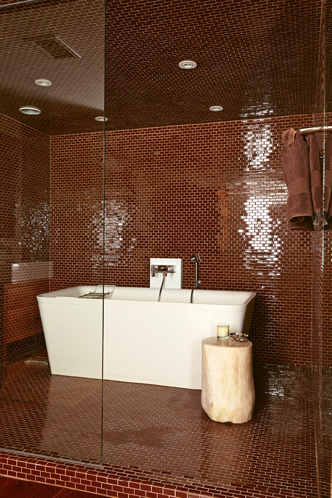 GLITTERING TRIBUTE: Designer de Givenchy chose the jewel-like glass subway tile in this bath to mimic the brick that’s found throughout the historic district.